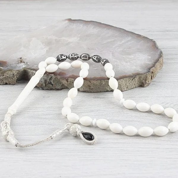 سبحة من عظم الجمل مع شرابة فضية ومكتوب عليها الاسم